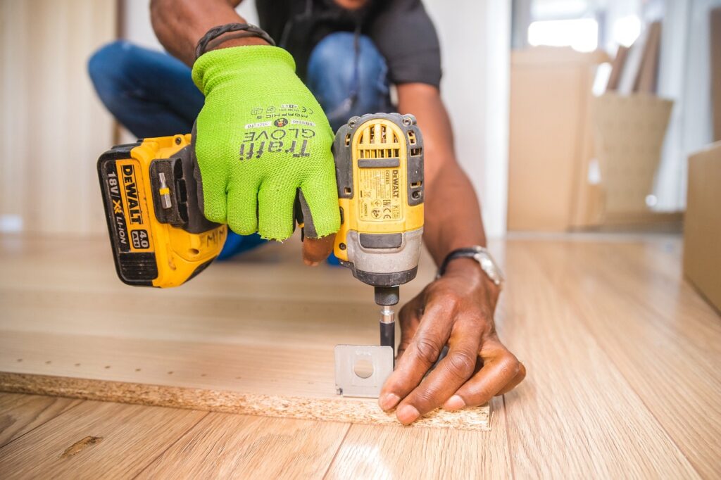 Handyman in Ajax using a power drill for furniture assembly and repair, serving Durham Region including Whitby, Oshawa, and Pickering